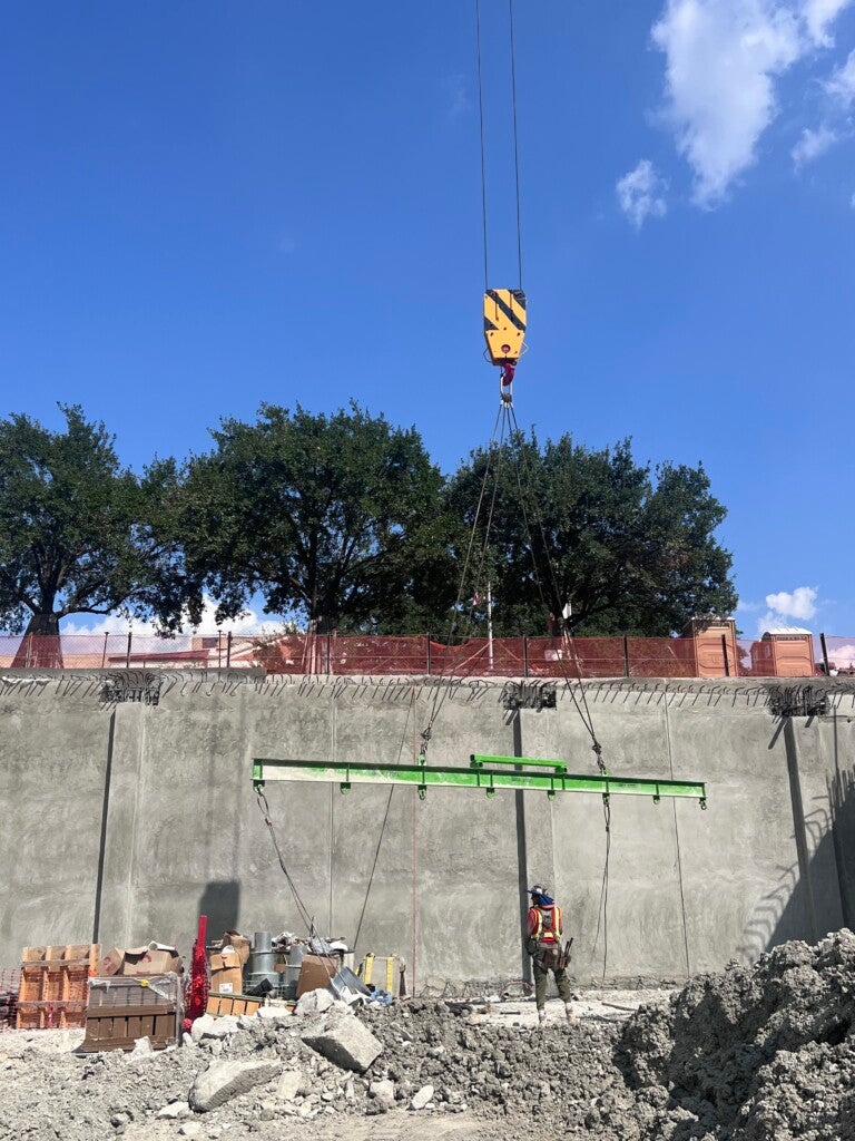Crane using a hoist to position reinforcement bar panels in place, Sept. 18, 2025